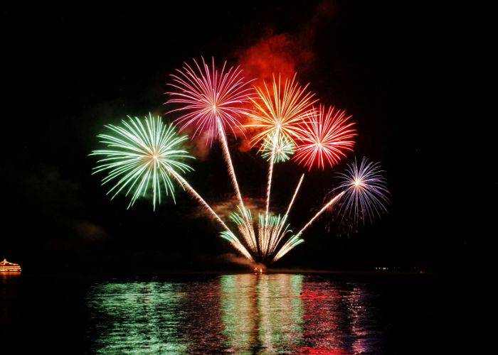 Hanabi matsuri, a firework festival with fireworks being set off over rippling water.